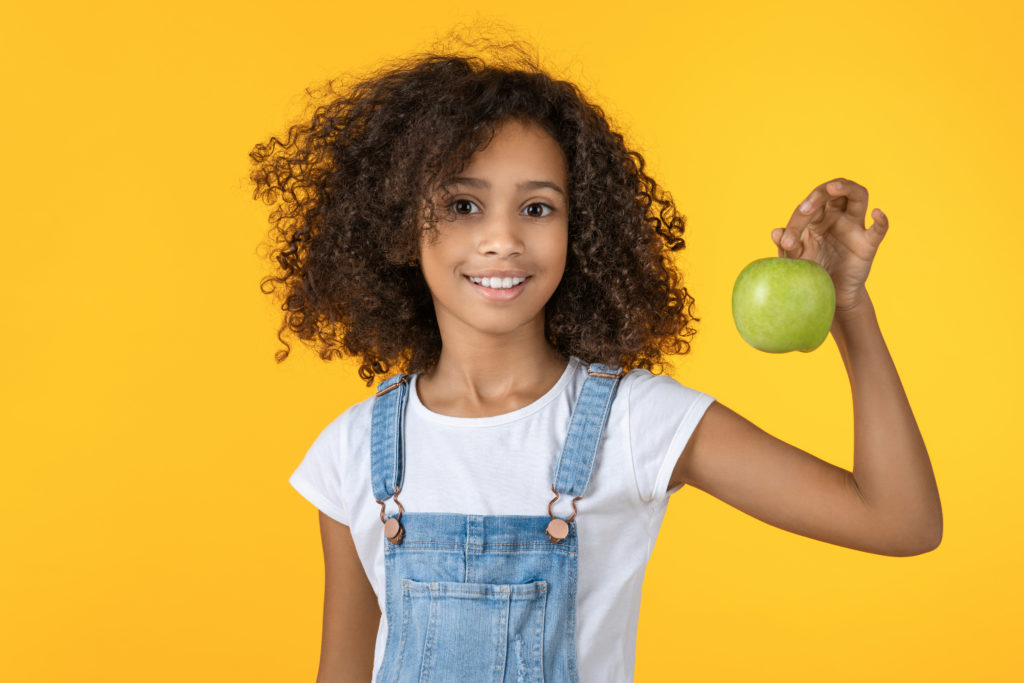 Photo: young girl with a green apple