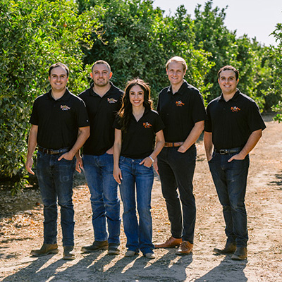 Family of farmers standing in an orchard