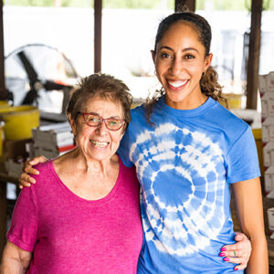 Smiling older and younger woman in a fruit packing shed