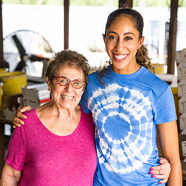 Smiling older and younger woman in a fruit packing shed