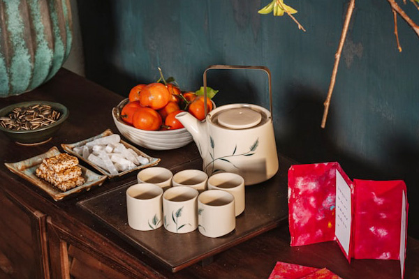Side table with tea set and mandarin oranges in a bowl