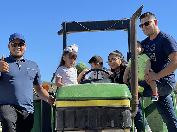 Two men and three kids on a tractor