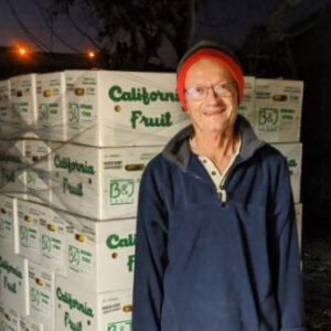 Farmer standing in front of boxes of fruit